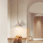 A wide-shade Clérachic pendant hangs in an arched hallway, lighting a small wooden desk and stool below.