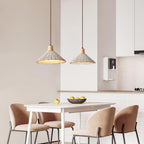 Two wide-shade Clérachic pendants hang over a white dining table with blush chairs and a bowl of lemons in a small kitchen.