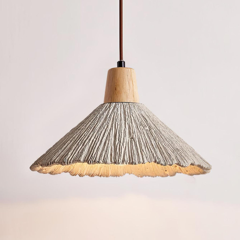 Lit wide-shade Clérachic pendant with a ridged grey surface, a wooden cap and a glowing warm underside.