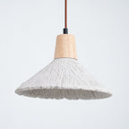 Close view of a wide grey Clérachic pendant with a wooden cap and a ridged shade, against a pale blue-grey background.