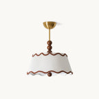 Clérachic pleated fabric ceiling light with a white tapered shade, wavy brown trim, stacked walnut beads and a brass canopy, on a white backdrop.