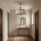 Clérachic beaded pendant-style ceiling light hanging beneath a plaster rose in a panelled hallway with dark wooden doors.
