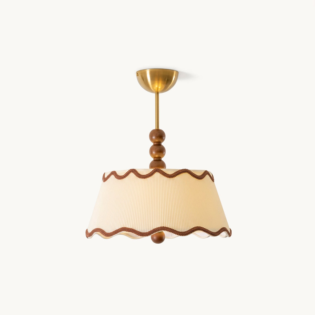 Lit Clérachic pleated ceiling light in warm cream with wavy brown trim and a brass canopy, on a plain white backdrop.