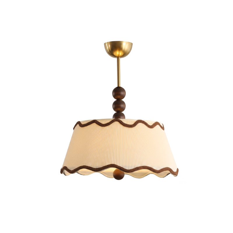 Clérachic ceiling light with a softly lit pleated shade, brown braid trim, walnut beads and a brass canopy, on white.