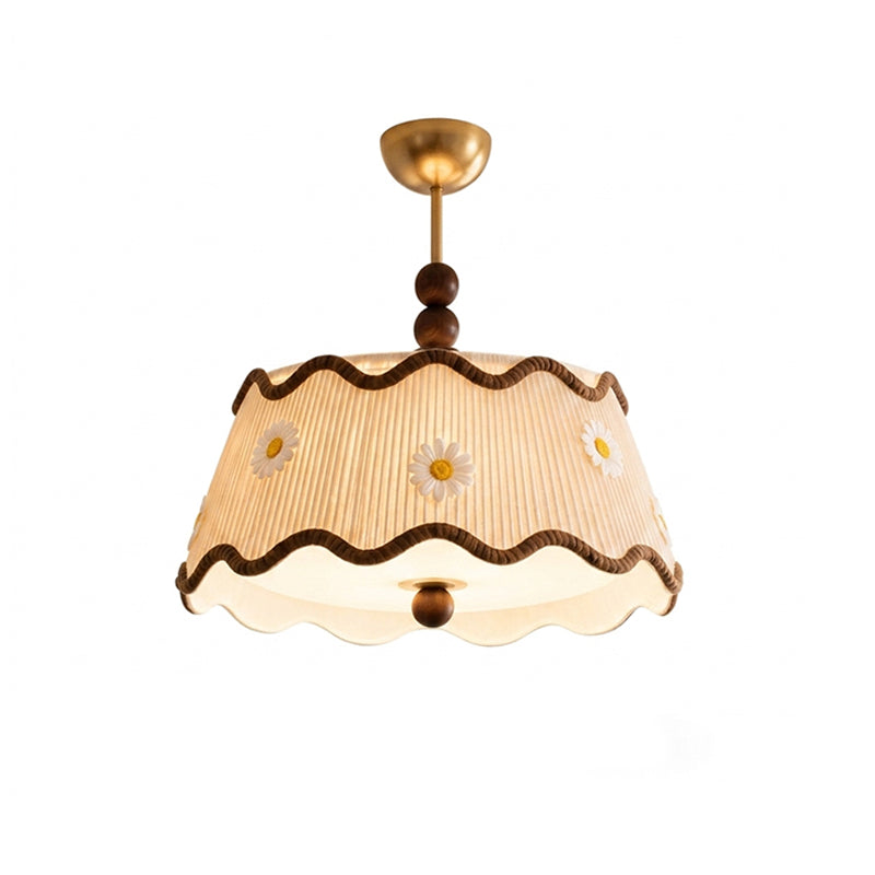 Lit Clérachic ceiling light in a version with embroidered white and yellow daisies on the pleated shade, with wavy brown trim.