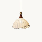 A beige pleated fabric Clérachic pendant light with a walnut cap and brass ball, hanging on a plain white backdrop.