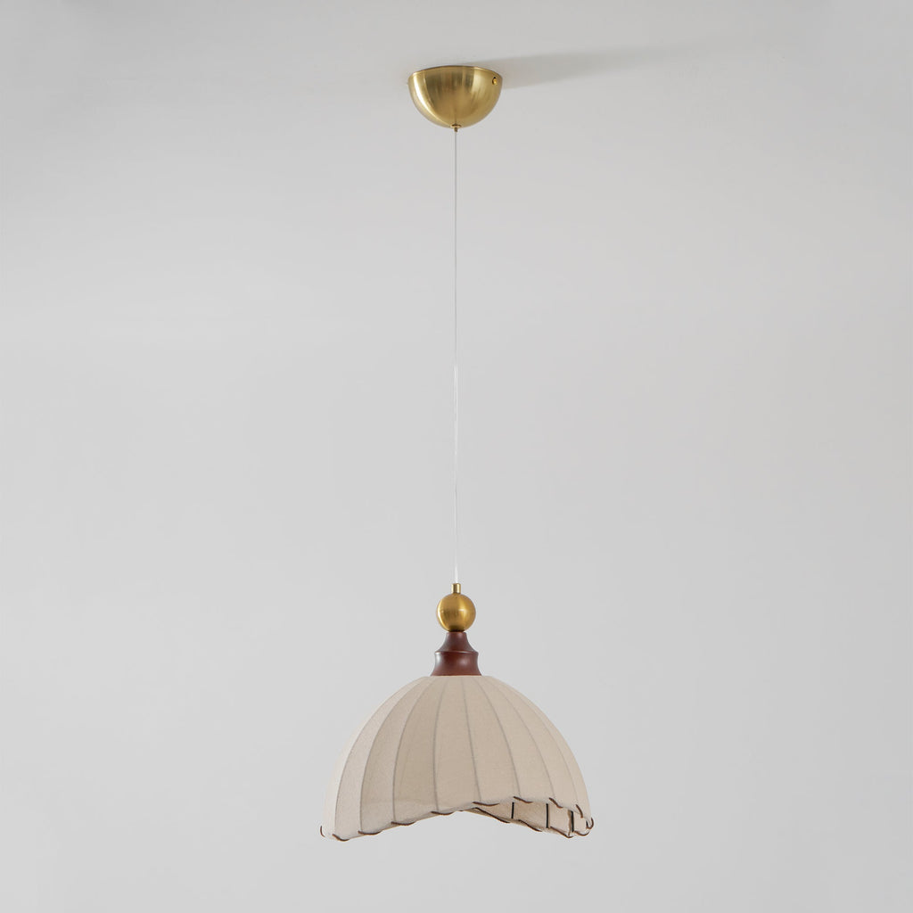 This Clérachic pendant light hangs far below its brass ceiling canopy on a long fine cord, on a pale grey backdrop.