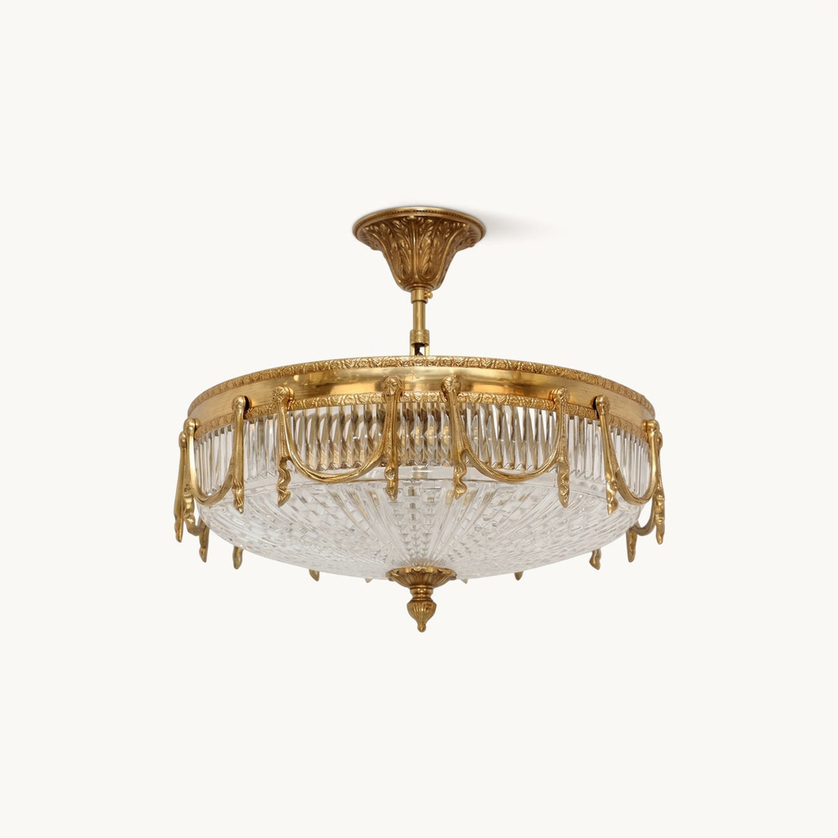 Brass flush-mount ceiling light from Clérachic with a pleated clear glass shade, shown on a plain white backdrop.