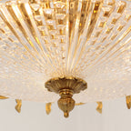 Close view of the radiating glass pleats and the brass finial beneath this Clérachic ceiling light.