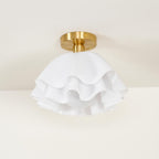 Clérachic Pleated Petal Ceiling Light fitted to a cream ceiling, the brushed brass canopy plate and its fixing screw in clear view.