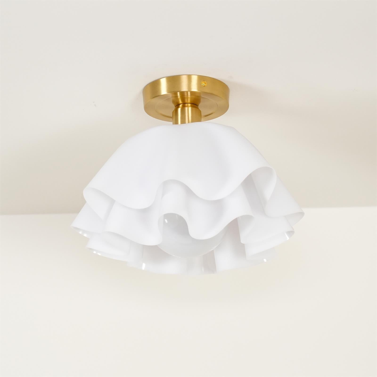 Clérachic Pleated Petal Ceiling Light fitted to a cream ceiling, the brushed brass canopy plate and its fixing screw in clear view.