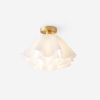 Angled studio shot of the Clérachic Pleated Petal Ceiling Light against white, the brass collar carrying the shade close to the ceiling.