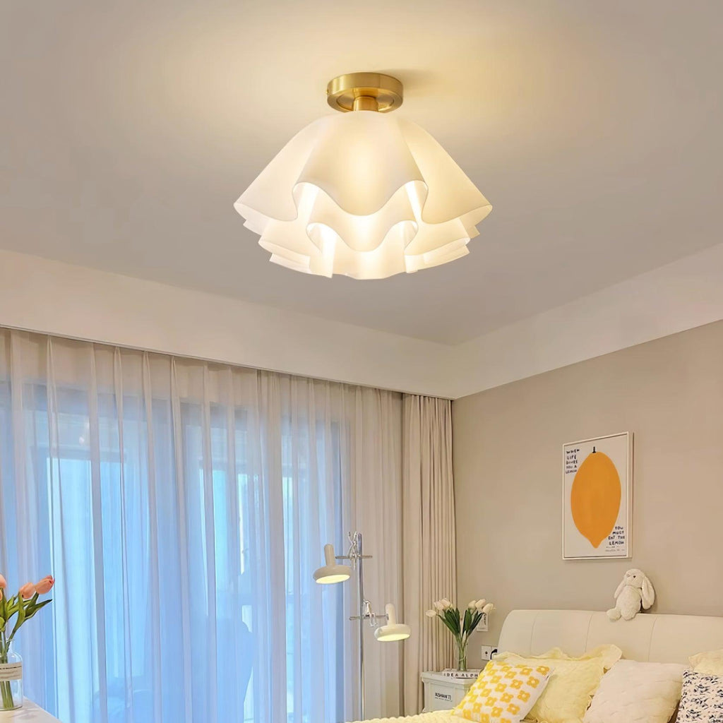 Lit above a bedroom, the Clérachic Pleated Petal Ceiling Light casts a warm glow across the ceiling beside sheer curtains and a bed.