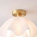Close view of the brass canopy plate on the Clérachic Pleated Petal Ceiling Light, fixed flat to the ceiling above the glowing shade.