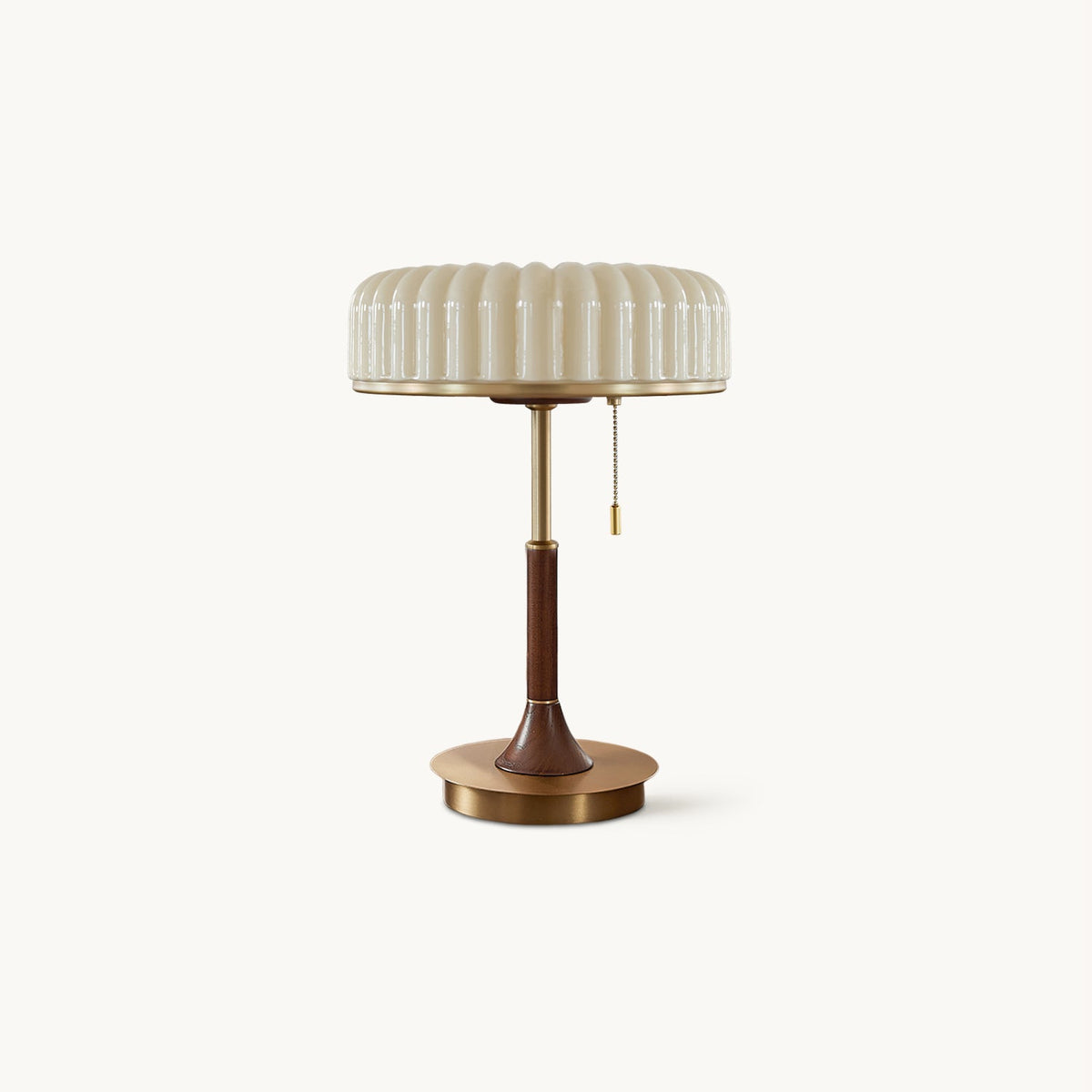 A Clérachic table lamp on a plain white backdrop, with a pleated beige shade, a walnut-wood stem and a round gold metal base.