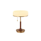 Cut-out view of this Clérachic table lamp, with its pleated cream shade, pull chain, walnut stem and round gold base.