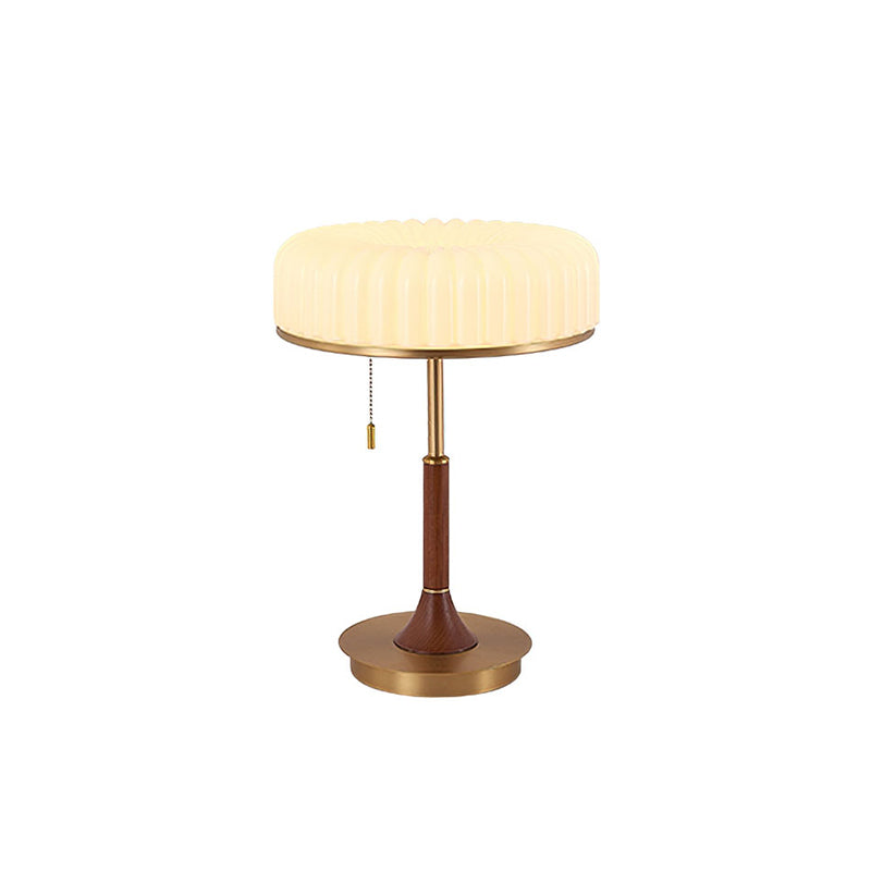 Cut-out view of this Clérachic table lamp, with its pleated cream shade, pull chain, walnut stem and round gold base.