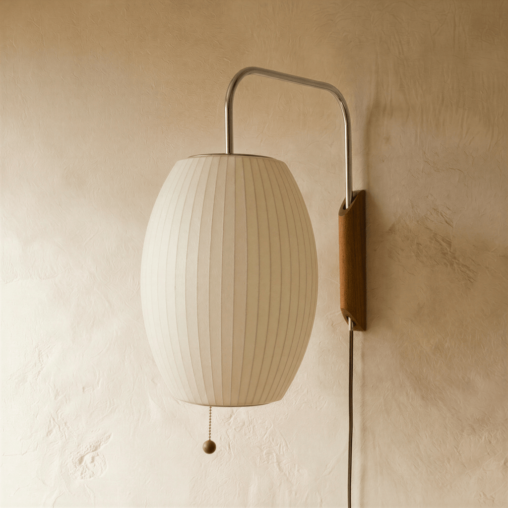 Clérachic barrel-shaped pleated white fabric wall lamp, switched off, on a chrome arm with a wooden mount and cord.