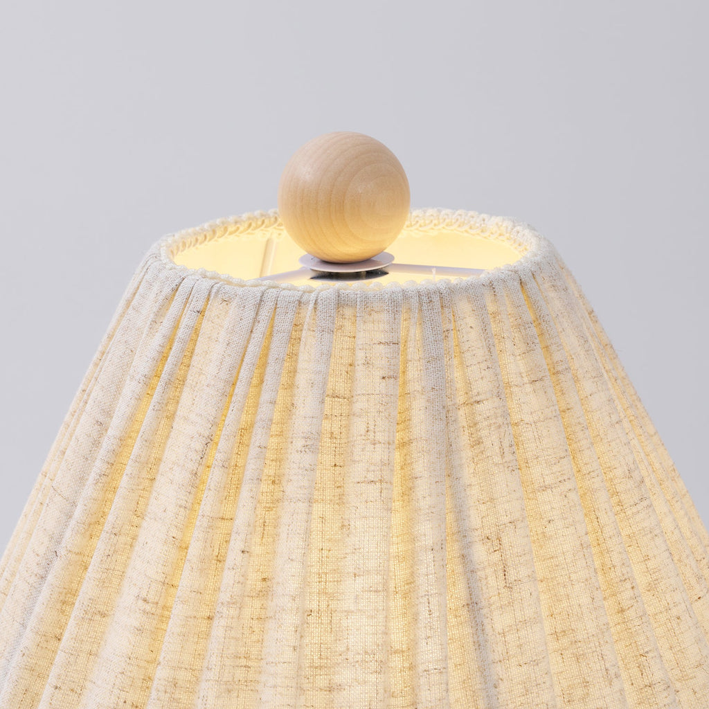 Close view of the wooden ball finial and gathered top edge of the linen shade on this Clérachic lamp.