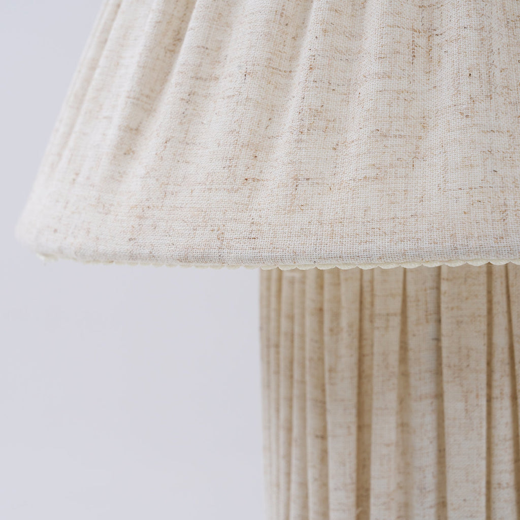 Close view of the shade's scalloped hem and the vertical pleats on the base of this Clérachic lamp.