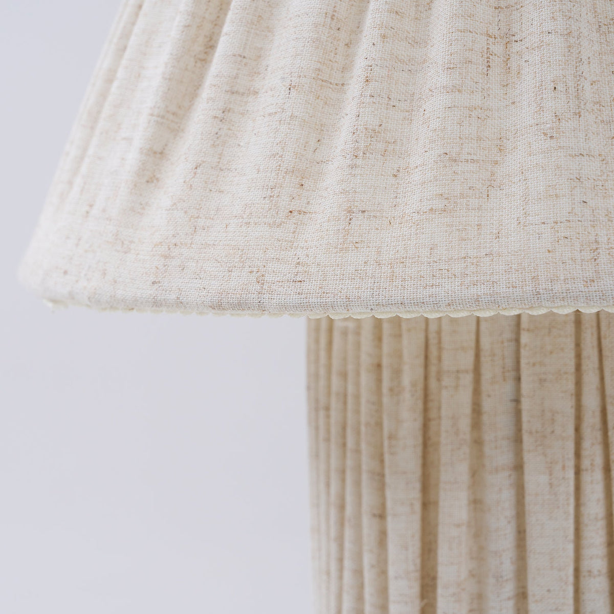 Close view of the shade's scalloped hem and the vertical pleats on the base of this Clérachic lamp.