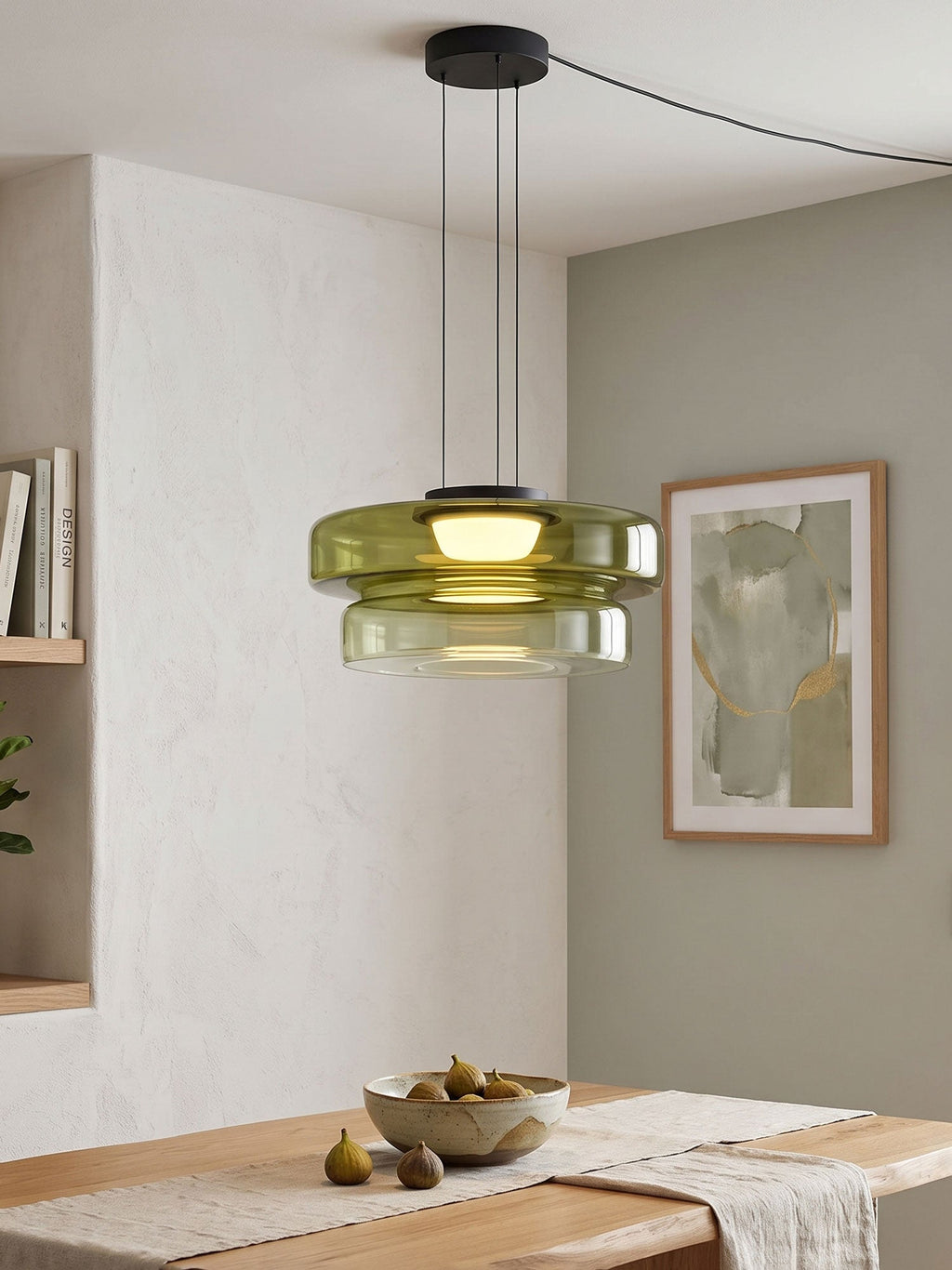 Green glass tiers on this Clérachic pendant hang beside a window with a framed print nearby.