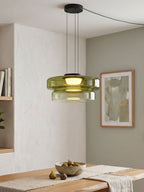 Green glass tiers on this Clérachic pendant hang beside a window with a framed print nearby.