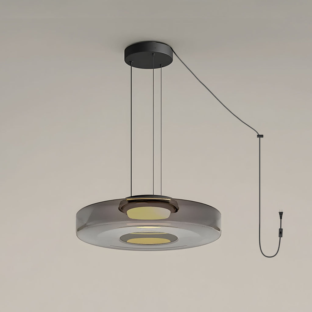 Close view of the cord and plug on this Clérachic pendant, its smoke-grey glass disc lit from below.