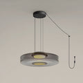 Close view of the cord and plug on this Clérachic pendant, its smoke-grey glass disc lit from below.