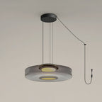 Close view of the cord and plug on this Clérachic pendant, its smoke-grey glass disc lit from below.