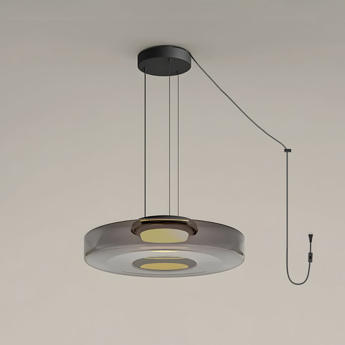 Close view of the cord and plug on this Clérachic pendant, its smoke-grey glass disc lit from below.