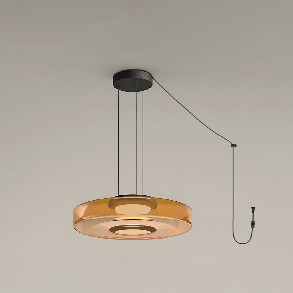 In amber glass, this Clérachic pendant shows its single tier and plug on a plain grey backdrop.