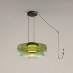 Two tiers of green glass stack on this Clérachic pendant against a plain grey backdrop.