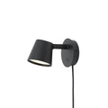 Black Clérachic wall light on a white background, its shade tilted forward and its cord hanging below.