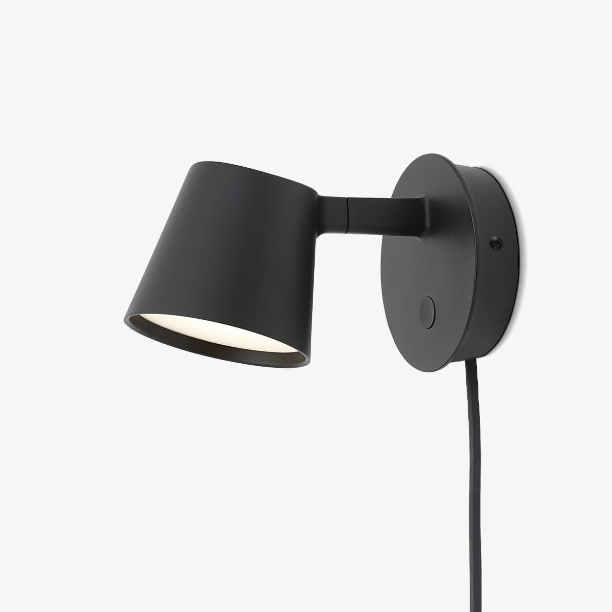 Larger studio view of a black Clérachic wall light on a light grey backdrop, showing the switch on the backplate.