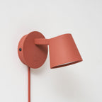 Red Clérachic wall light close up, the shade tilted forward with its white diffuser just visible below the rim.