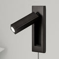 A square matt black head sits on a dark plate on this Clérachic wall light, angled out to the side on a grey wall.