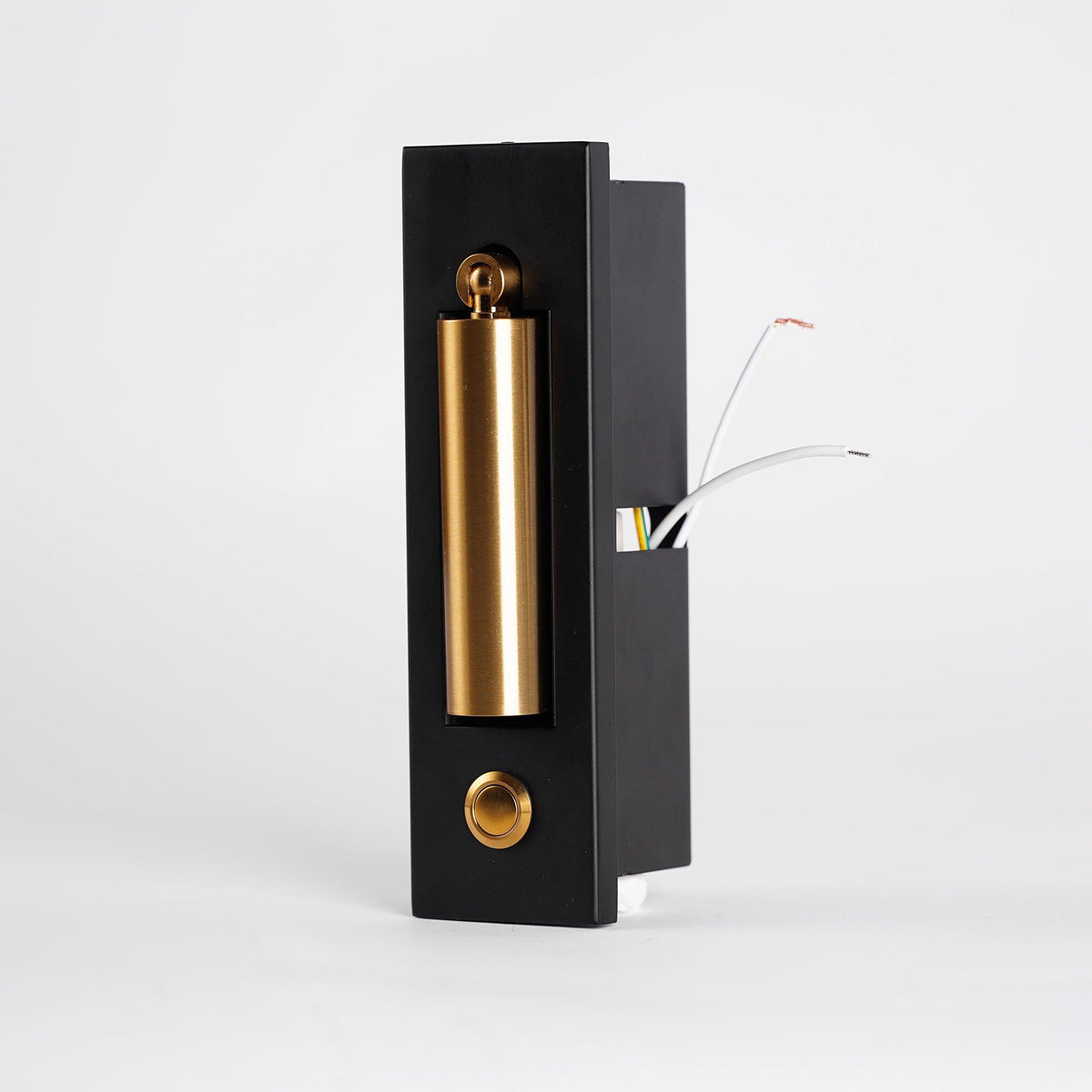 Angled view of the black back box of this Clérachic wall light, with a brass-coloured head, button and wires showing.