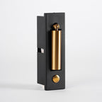 Side view of this Clérachic wall light, its brass-coloured head folded in and a round button on the black plate.