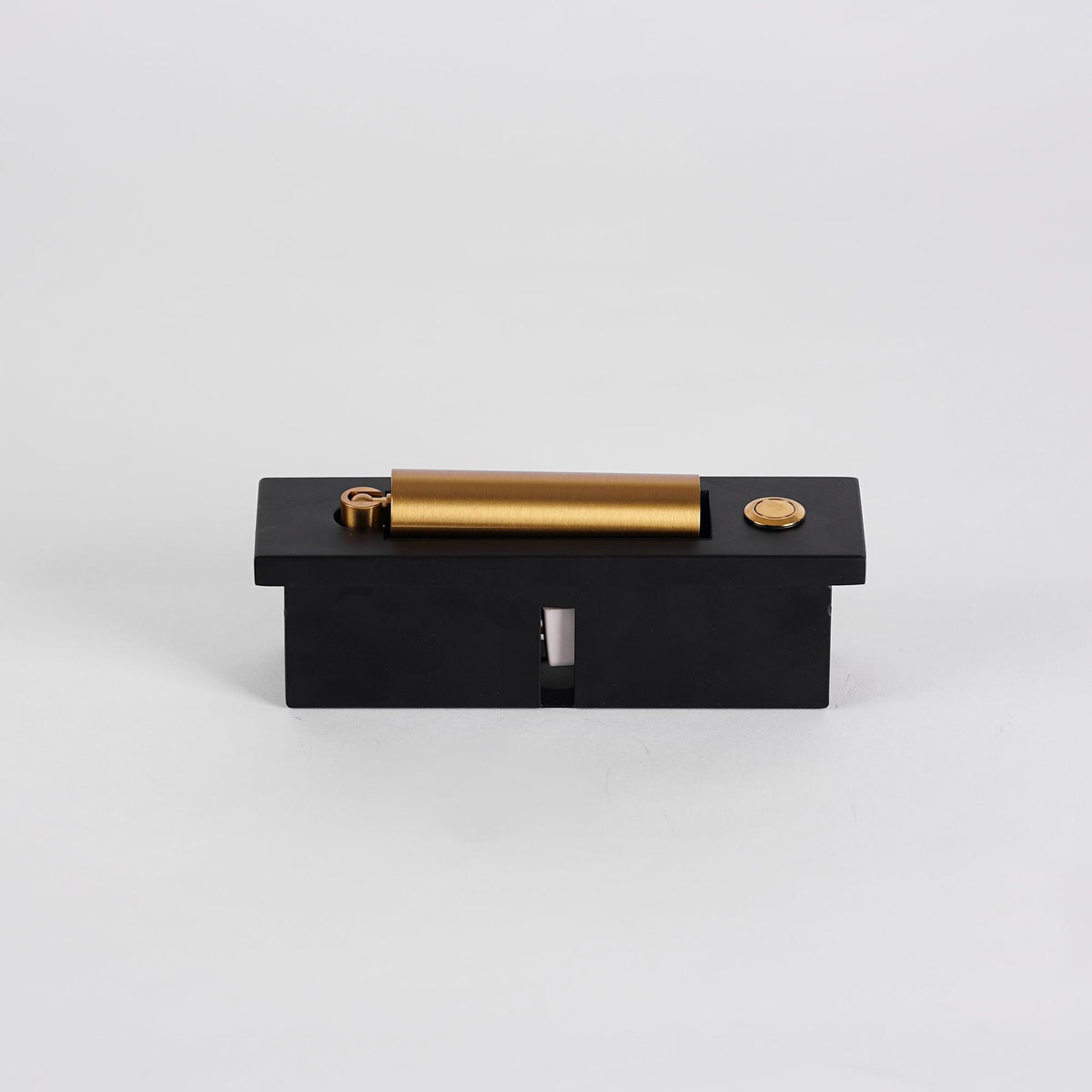 Top view of this Clérachic wall light lying flat, showing its brass-coloured head, round button and black back box.