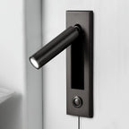 Black round head of this Clérachic wall light angled out from a dark plate, with a push button and a cable below.