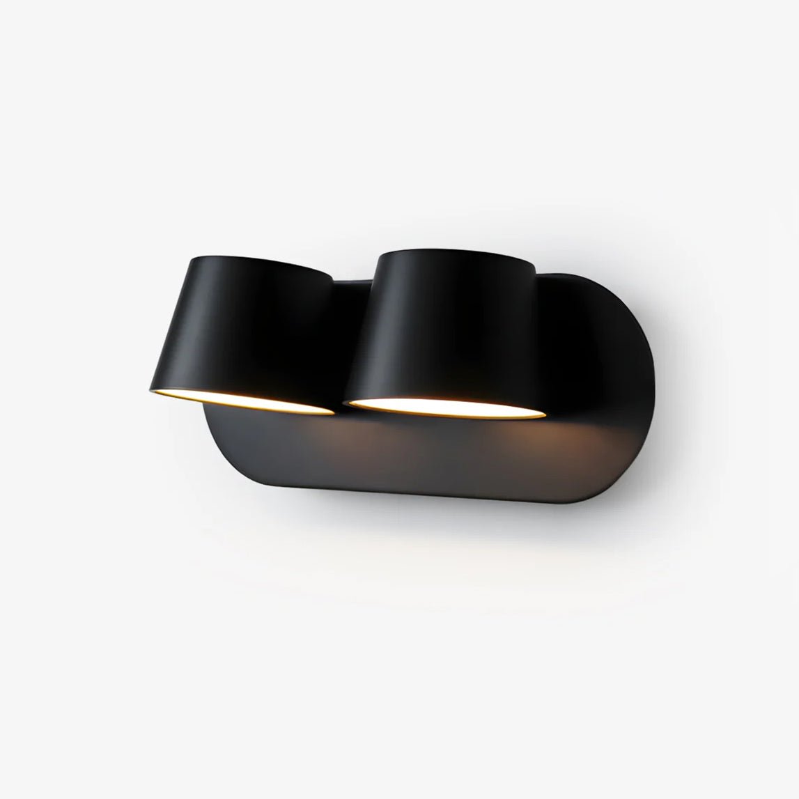 Black Clérachic wall light with two shades on an oval plate, shown on a plain white backdrop with the lit faces turned down and to the side.