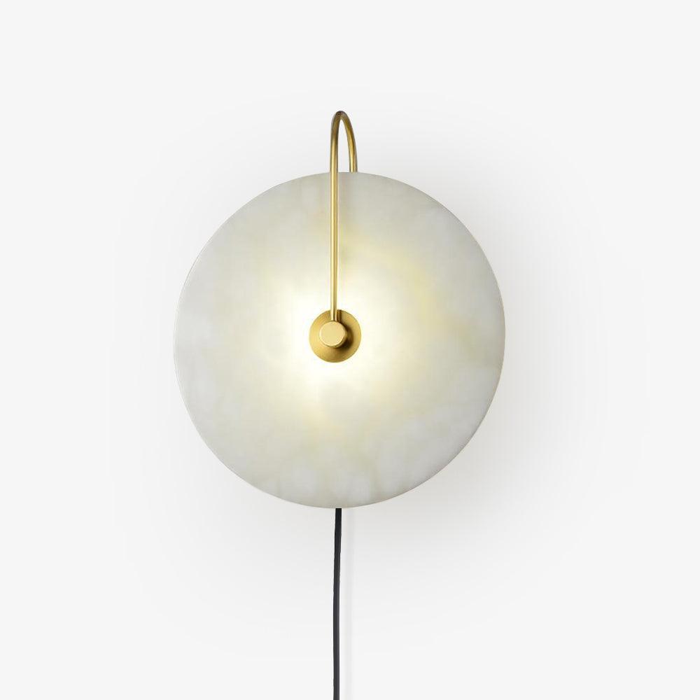Clérachic Plug-In Wall Sconce on a plain grey backdrop, gold arm and a gently lit alabaster globe shade.