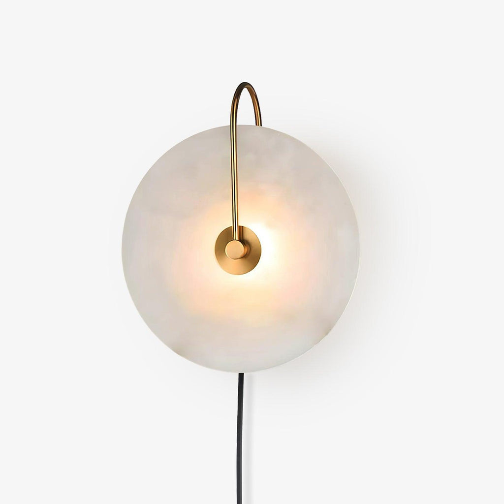 Front view of the Clérachic Plug-In Wall Sconce on a white studio backdrop, glow centred behind the gold hub.