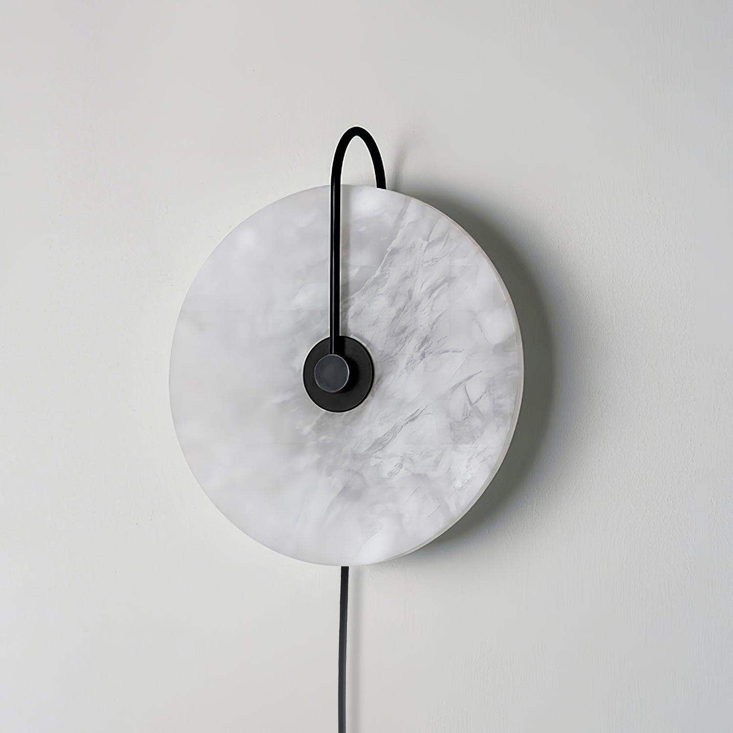Clérachic Plug-In Wall Sconce in the black finish, switched off, with grey veining across the unlit stone disc.