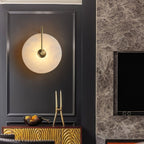 Gold-arm Clérachic Plug-In Wall Sconce centred in charcoal wall moulding above a gold console with a bowl of citrus.