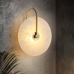 Angled Clérachic Plug-In Wall Sconce on dark textured concrete, gold arm and amber veining with palm fronds below.