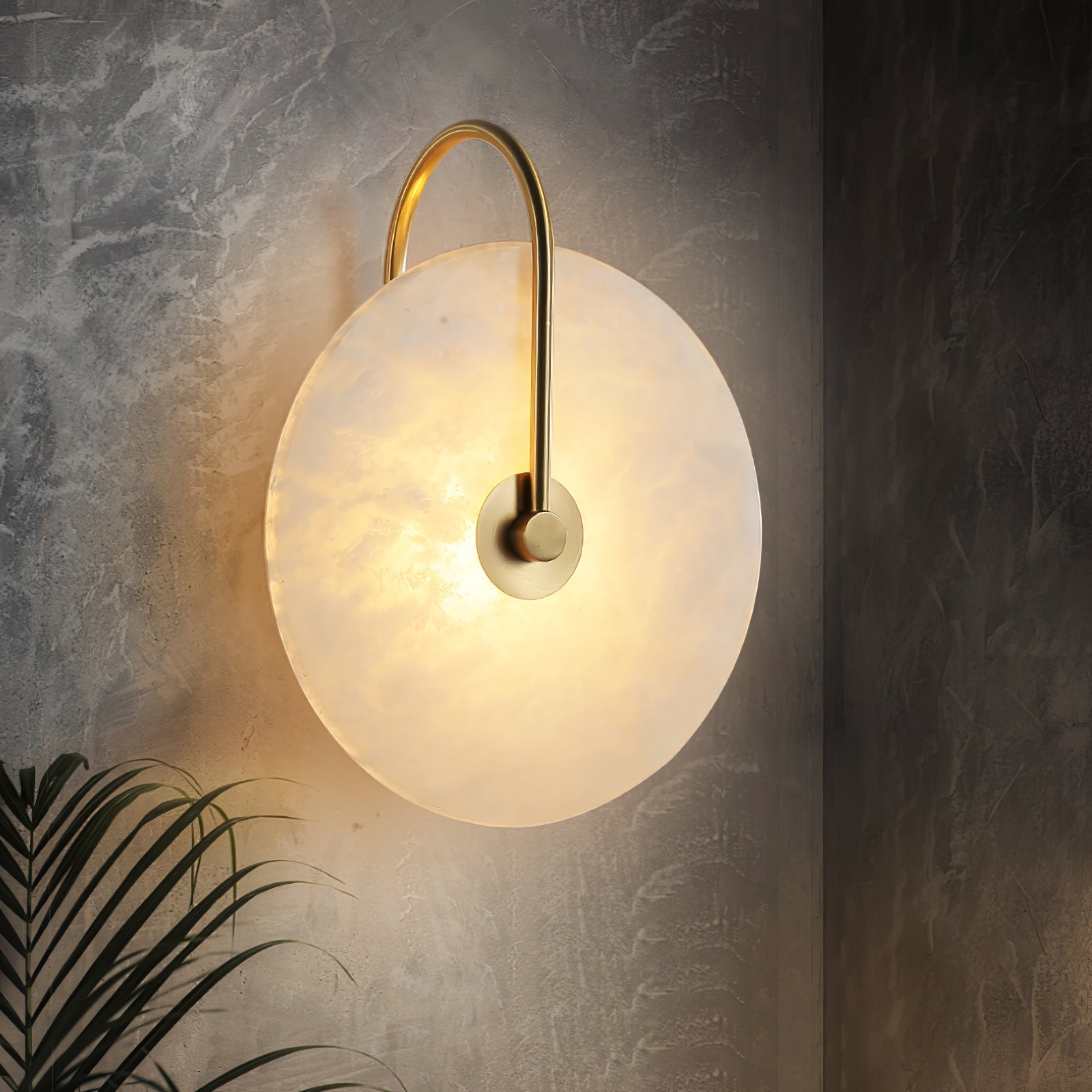 Angled Clérachic Plug-In Wall Sconce on dark textured concrete, gold arm and amber veining with palm fronds below.