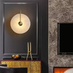 Gold-arm Clérachic Plug-In Wall Sconce in charcoal moulding above a textured gold sideboard, with a fireplace and screen beyond.