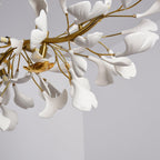 Detail of fine gold stems and white leaves, with a small gold bird ornament near the centre of this Clérachic chandelier.